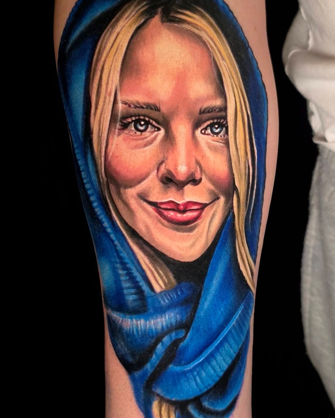 Tatouage de portrait réaliste couleur encadré d’un tissu bleu profond