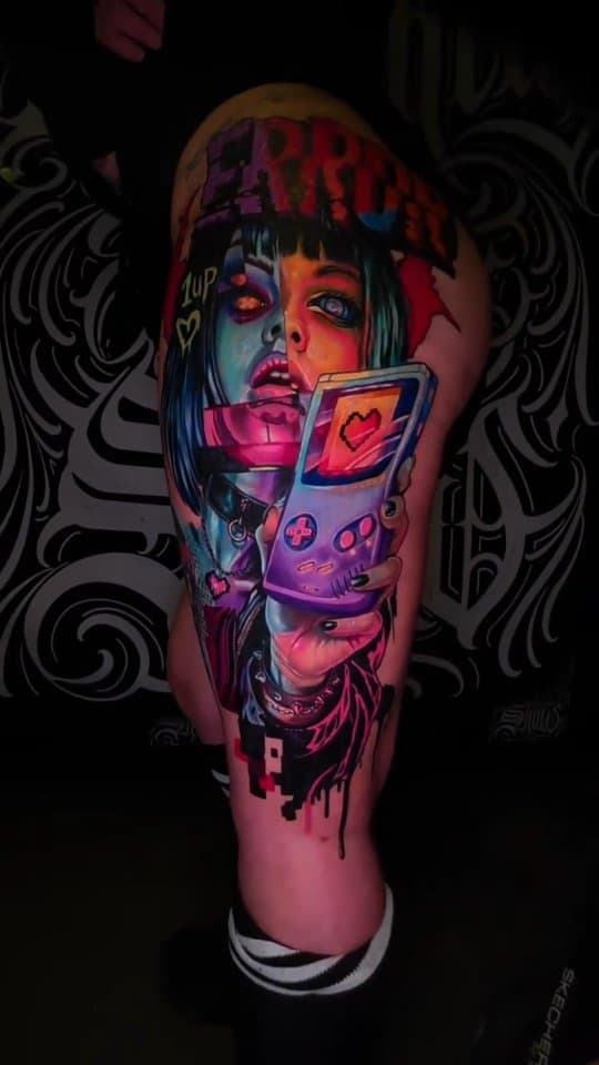 Tatouage couleur de Pat X combinant portrait, jeu vidéo et esthétique glitch
